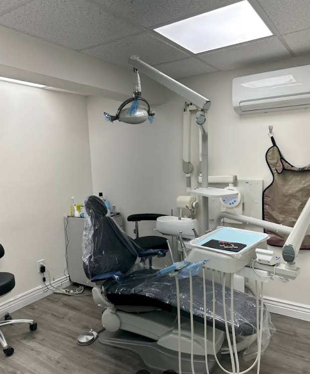 The image shows a dental office interior with a dental chair, dental equipment, and a clean, professional appearance.